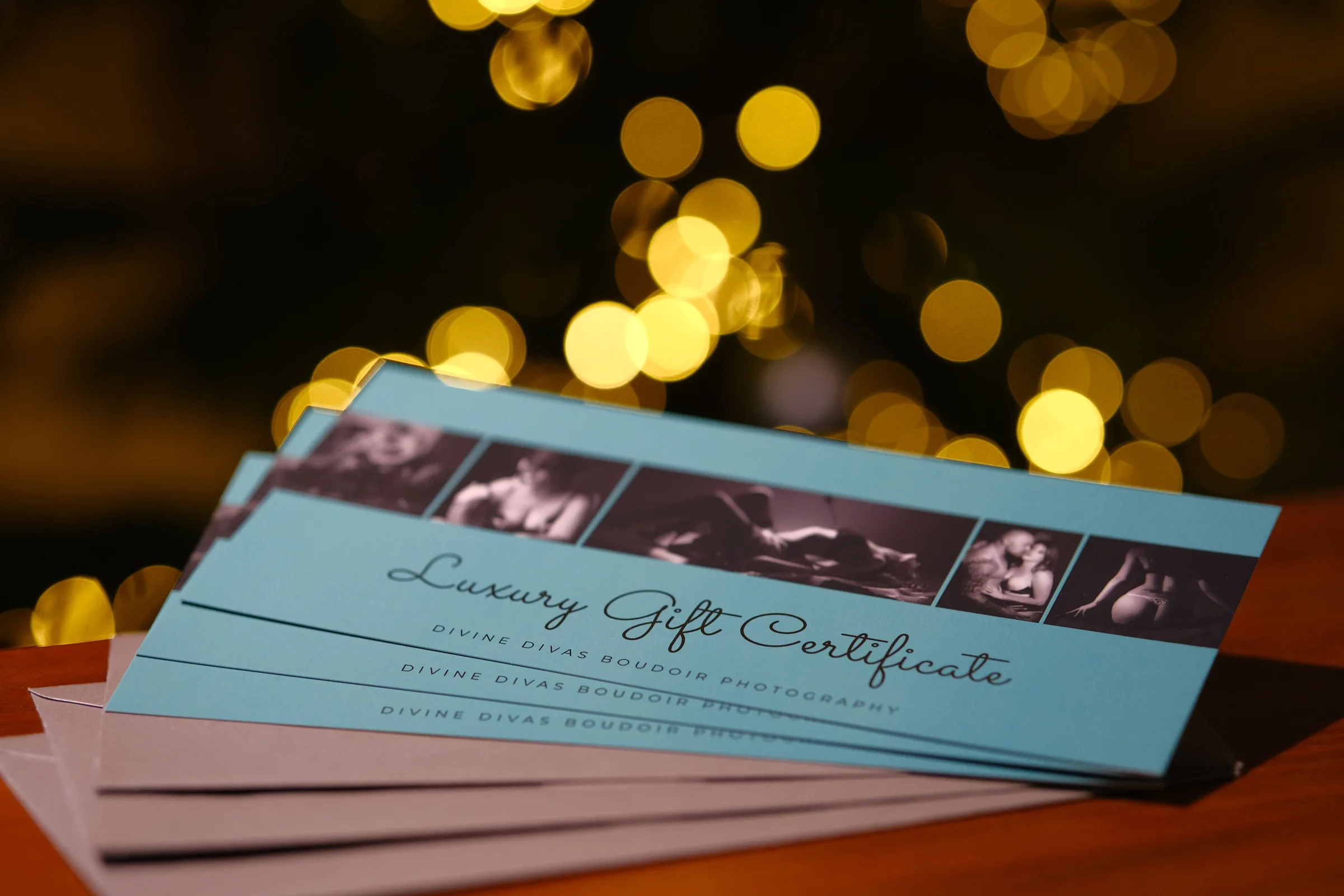 Divine Divas luxury gift certificates on a table with warm lights behind